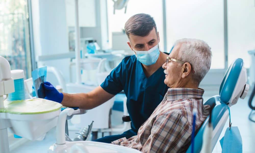 Dentist showing x-ray to senior male.